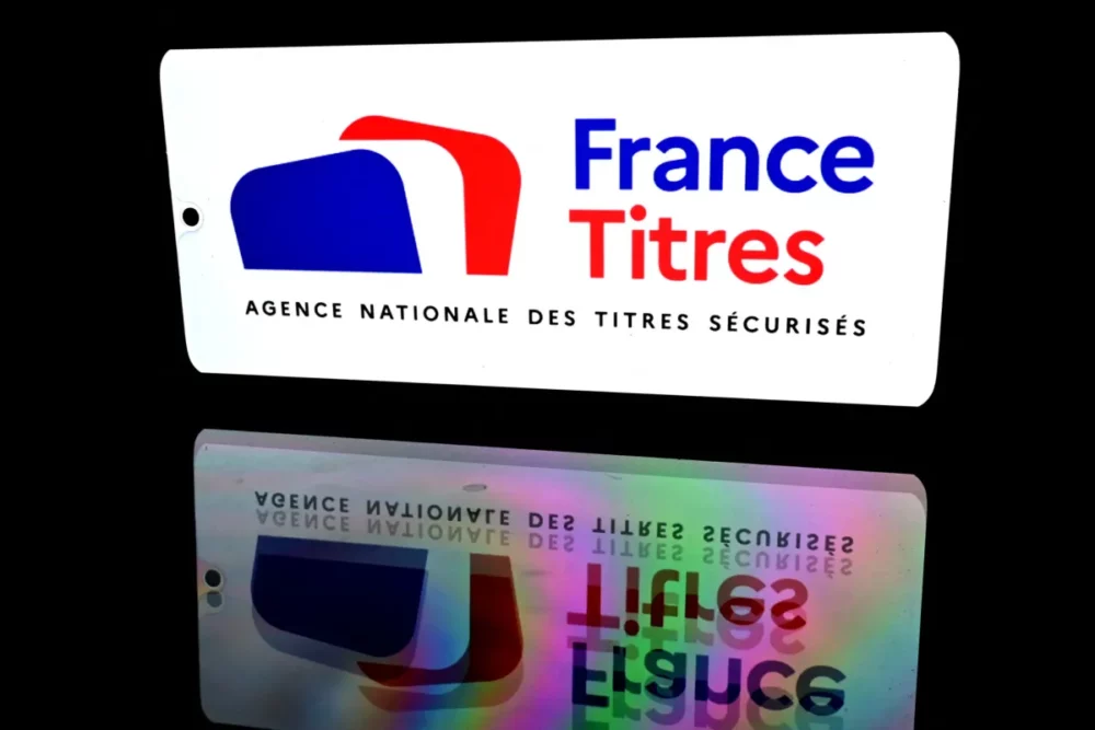 White sign with the France Titres logo (blue 'France', red 'Titres') on a black background, with a reflected image below.