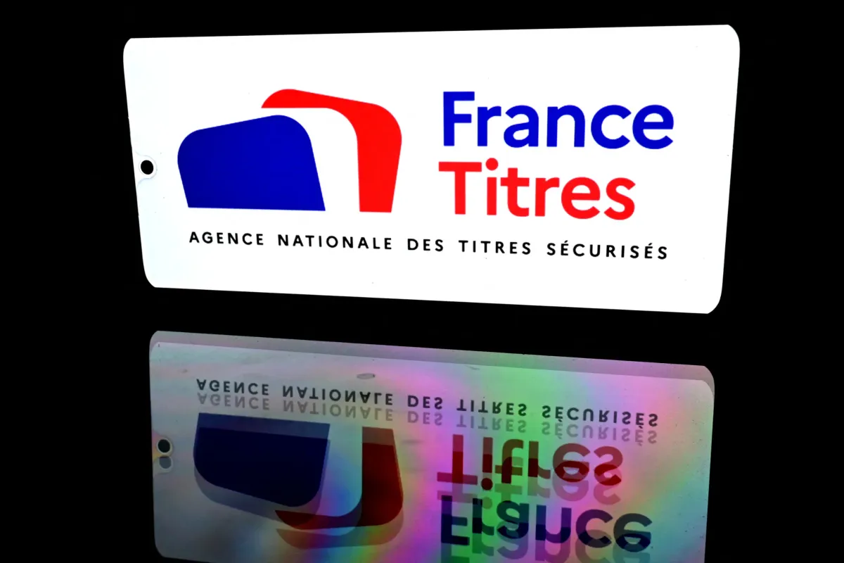 White sign with the France Titres logo (blue 'France', red 'Titres') on a black background, with a reflected image below.