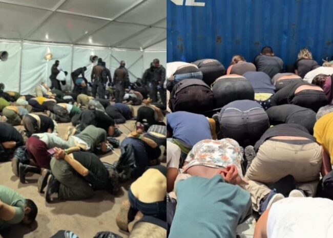 Large group of people kneeling and bowing in prayer inside a temporary shelter or tent, crowded on the floor.