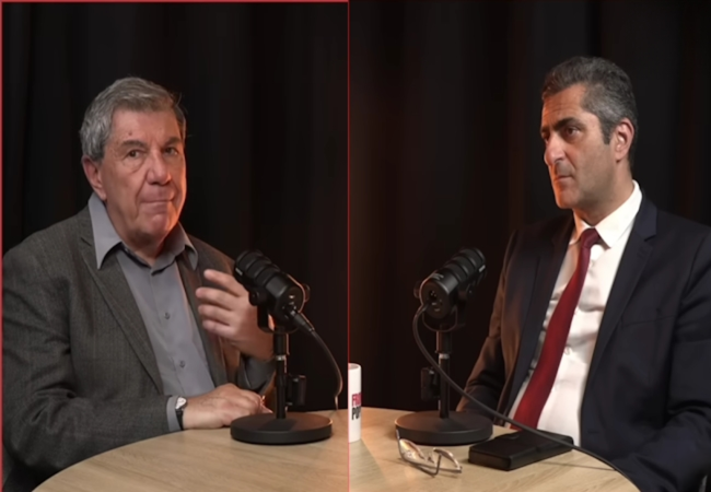 Two men sit at a round table with microphones, appearing to host a podcast or interview in a studio.